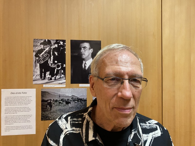 Hans Weiss anlässlich der Ausstellungseröffnung am Freitag vor einem Porträt und Fotos seines Vaters.