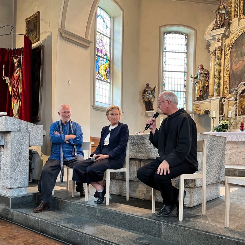 Peter Zumthor, Irmgard Frank und Pater Martin in der Kuratiekirche am Podium (© M PS)