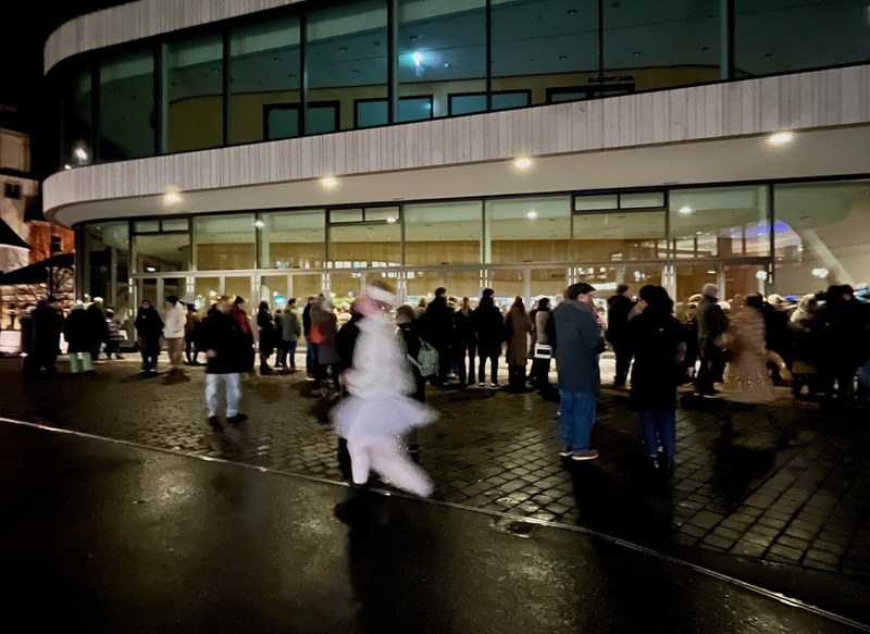 Eine ungewohnte Schau-Fenster-Performance. Das Publikum steht erwartungsfroh vor dem Montforthaus. (Foto: MPS) 