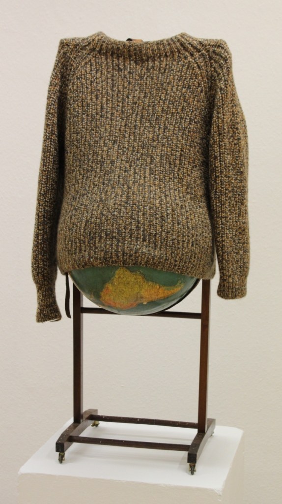 Anne Marie Jehle: Ohne Titel (Die Welt). Wollpullover, Globus, Ledergürtel, Holz (stummer Diener)