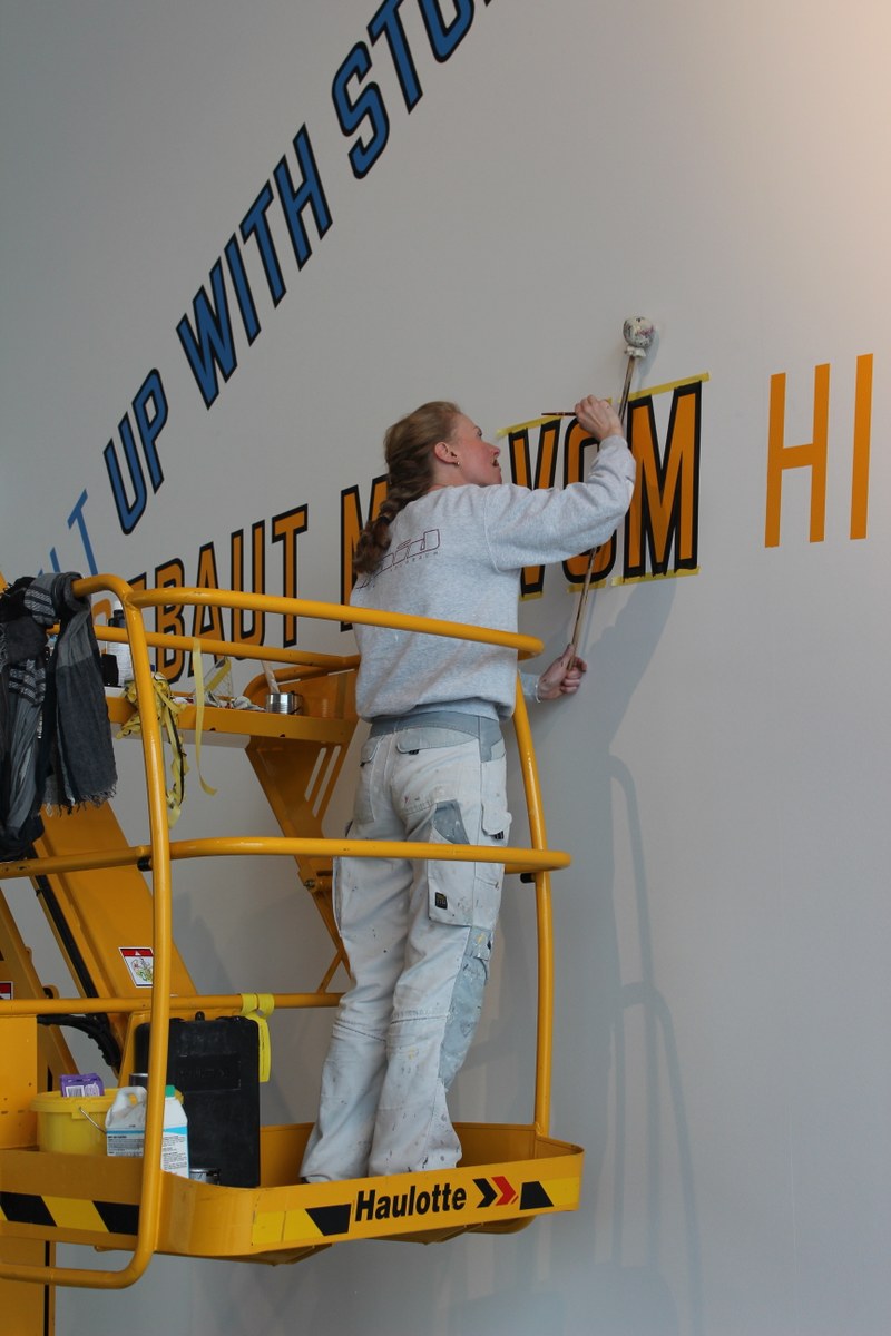 Präzisionsarbeit: Die Krumbacher Malermeisterin Gabriele Raid installiert die Schriftbilder von Lawrence Weiner