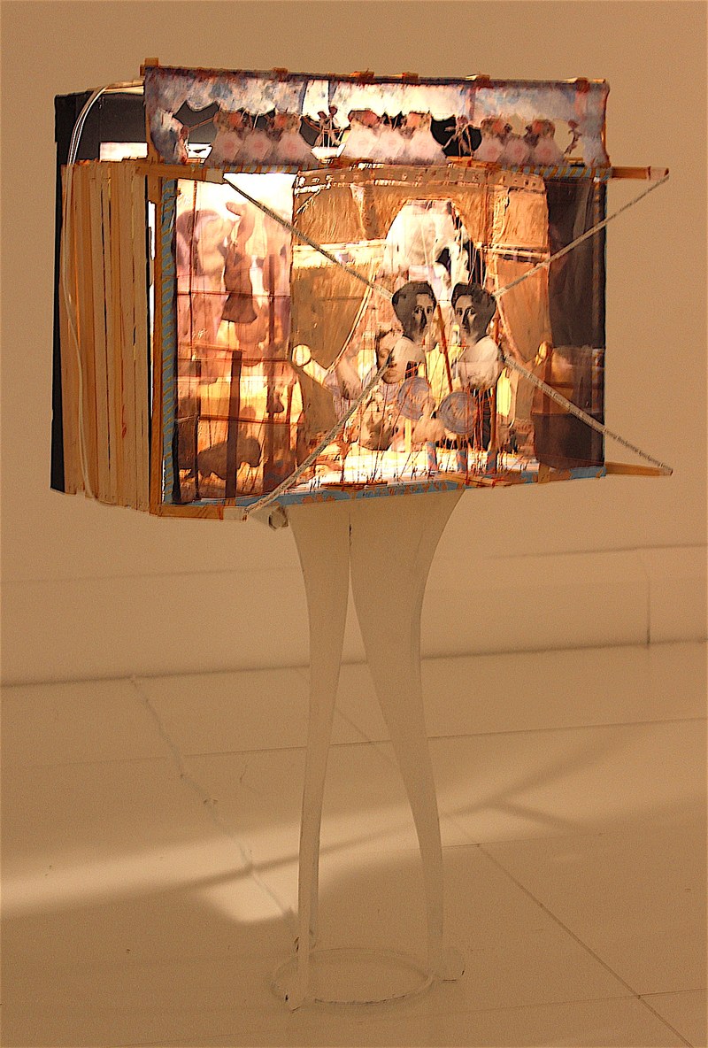Susanne Keller: "Das Wachsfiguren-Kabinett", 2008, Holz, Karton, Folienbilder, Faden, Metall, Text, Tischelement, Acryl, internes Licht