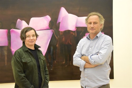 Kuratorin Andrea Fink und Künstler Ingmar Alge vor dem großformatigen Gemälde "Protest"