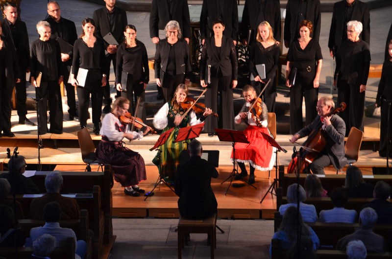 Clau Scherrer, der Chor Cantus Firmus Surselva und das Ensemble „le phénix“ im Altarraum von St. Karl (Foto: Christoph Wallmann).