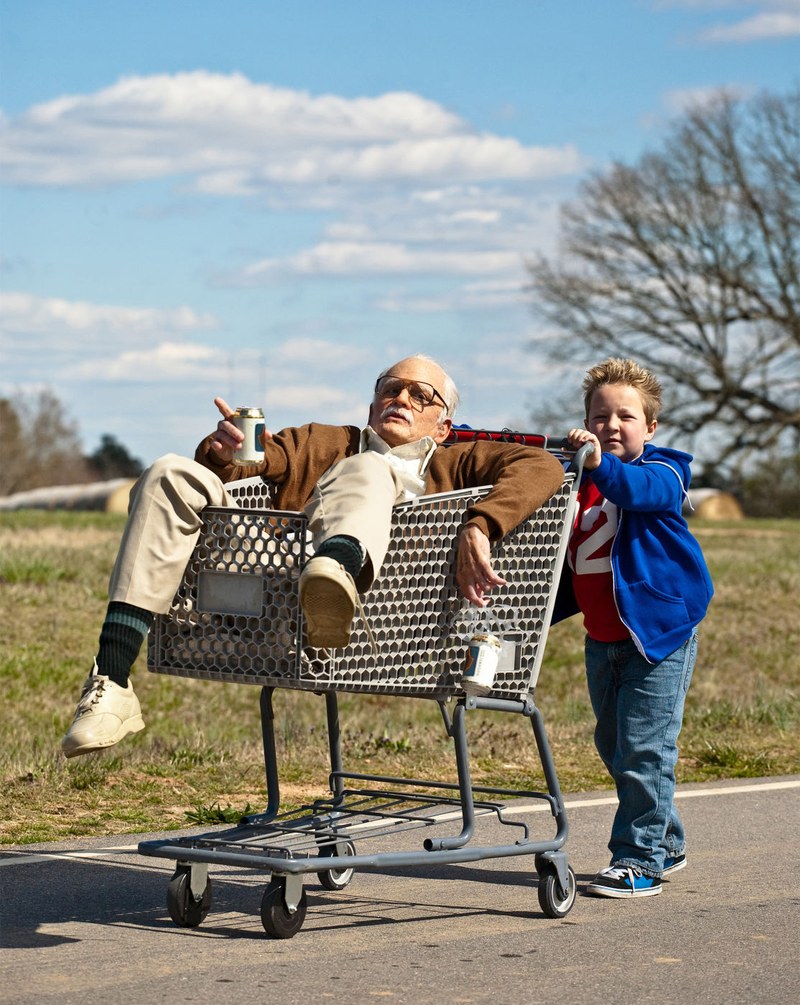 So ein Spaß: Der kleine Enkel führt den alten Opa im Einkaufswagen.
