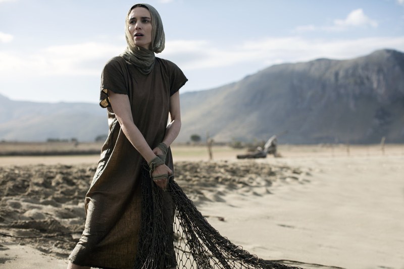 Rooney Maria als Fischerin mit Netz. Später wird sie in den Gewässern Frauen taufen.