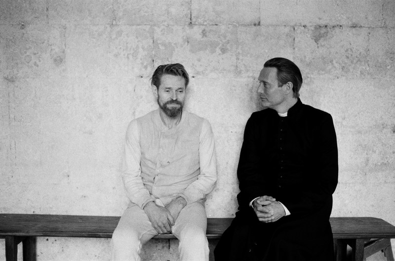 Set-Foto: Mads Mikkelsen als Priester prüft Willem Dafoes Intellekt. Eine Schlüsselszene, auch für die erzählerische Haltung dieses Films.