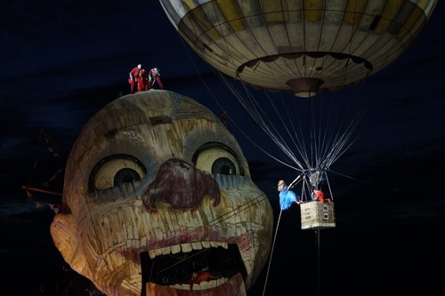 Nach ihrer Arie „Caro nome“ im Heißluftballon in 15 Metern Höhe wird Gilda von Helfern abgeseilt und entführt, unter den besorgten Blicken des Rigoletto-Kopfes.