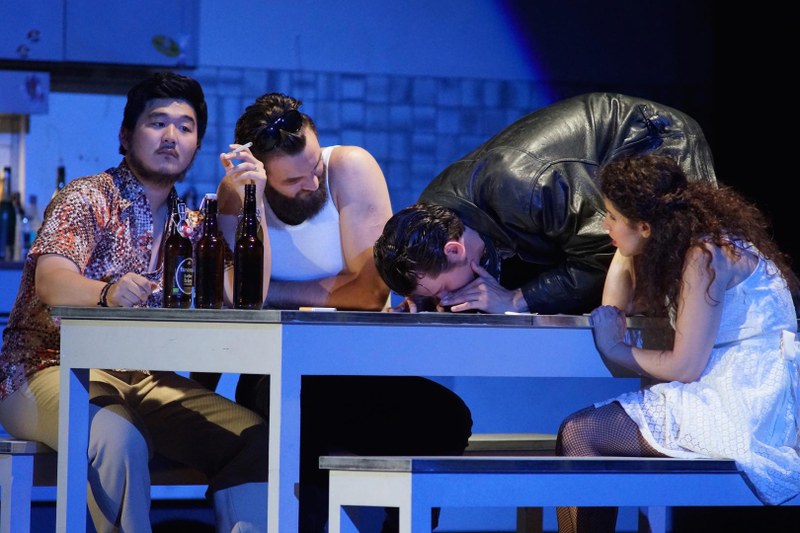 Nach der temperamentvollen „Champagner-Arie“ Don Giovannis wird im Kreise der Verflossenen und Angebeteten gefeiert, gekifft, geraucht und gesoffen, was das Zeug hält (v.l.n.r. Masetto (Jung Rae Kim), Leporello (David Ostrek), Don Giovanni (Wolfgang Stefan Schwaiger) und Zerlina (Hagar Sharvit).