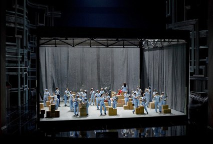 Wagners „Spinnstube“ wird in Jan Philip Glogers Regie zur Abfertigungshalle unzähliger Ventilatoren, die in Pappkartons verpackt werden (Bühne: Christof Hetzer, Kostüme: Karin Jud).